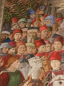 Corteo del Mago giovane tra i personaggi della terza fila dal basso, alla destra dell’uomo con la barba, il ritratto di Benozzo sul suo cappello rosso una scritta in oro recita “Opus Benotii”