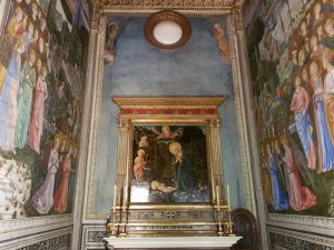 Predella sopra l’altare la copia dell’Adorazione del Bambino di Filippo Lippi. Ai lati le schiere angeliche