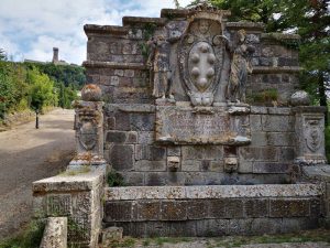Fontana medicea di Radicofani. Sullo sfondo, la torre del castello