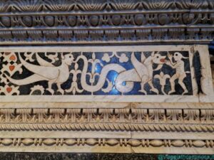 Dettaglio dell'intarsio marmoreo nella transenna del presbiterio, con draghi e folletti