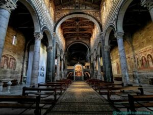 L'interno di San Miniato al Monte, con al centro della navata centrale il tappeto marmoreo e dietro la Cappella del Crocifisso