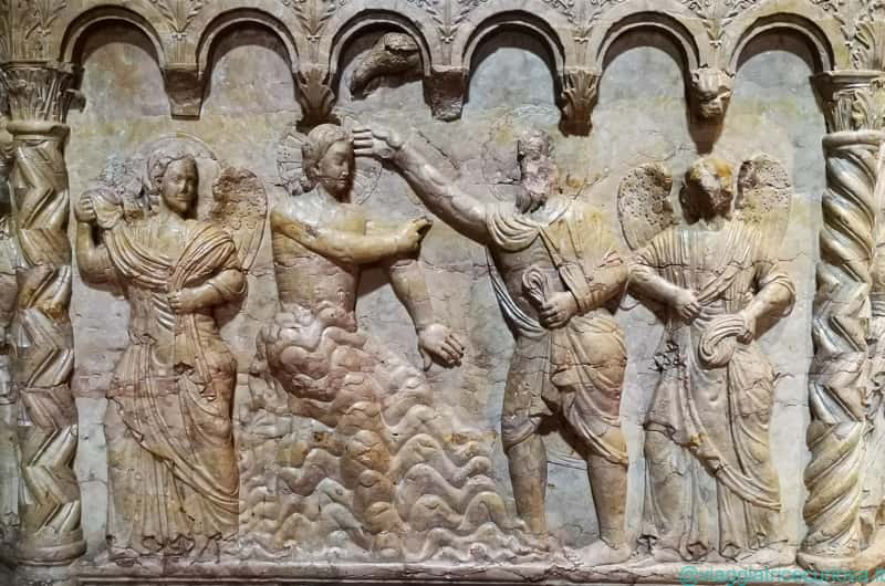 Fonte battesimale, formella del Battesimo di Gesù, con l'acqua del Giordano che arriva ai fianchi